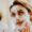 Young woman applying clay mask as part of her oily skin care routine at home