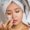 Woman applying facial cream with a towel wrapped around her head skincare routine for healthy and glowing skin